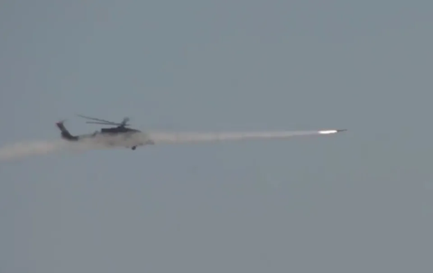 A Z-20T assault helicopter launches a KD-9 air-to-ground missile toward a target during a live-fire exercise
